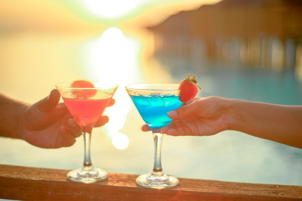 Two cocktails raised at sunset