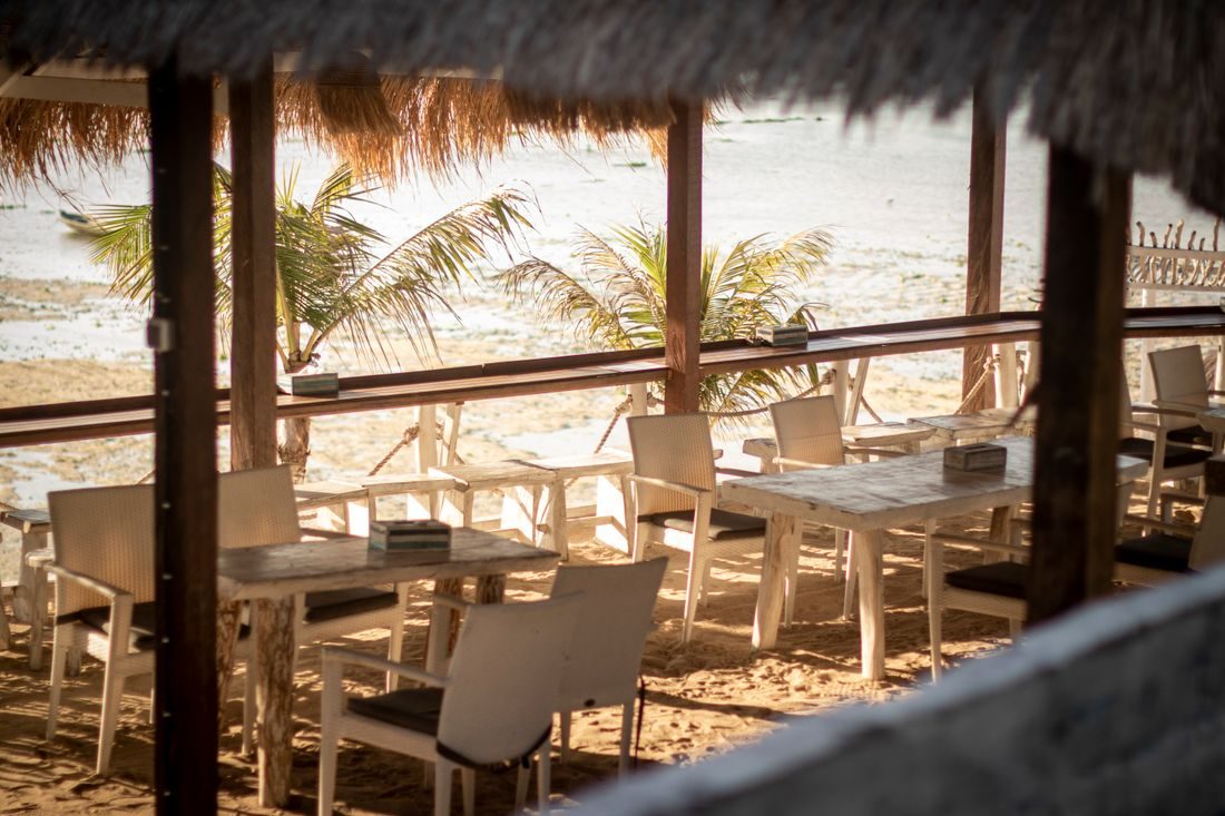 Tables under a thatched roof on the beach